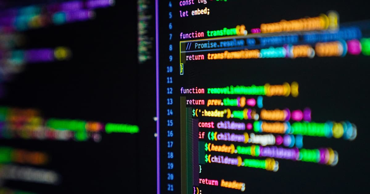 A computer screen displays colorful lines of programming code, with functions, variables, and syntax highlighted in blue, yellow, green, pink, and orange on a dark background.