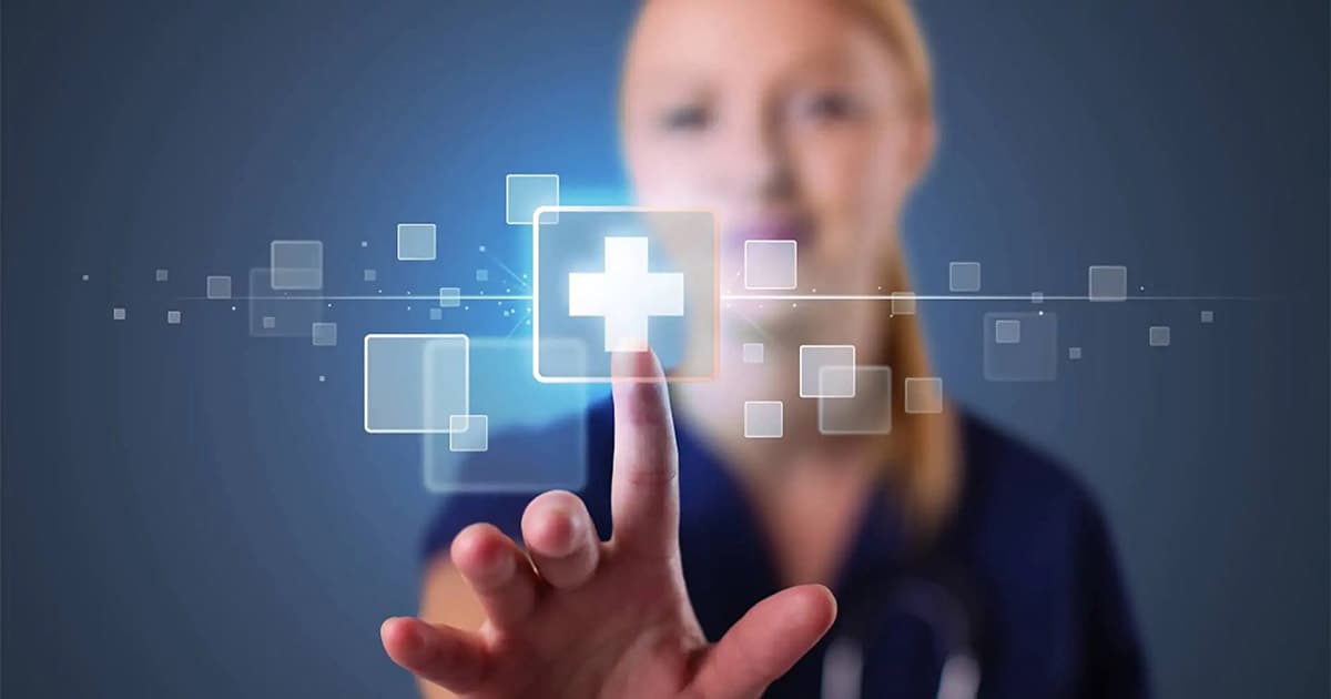 A woman in medical scrubs touches a virtual screen, selecting a glowing digital medical cross icon among floating squares, symbolizing healthcare technology. The background is blurred blue.